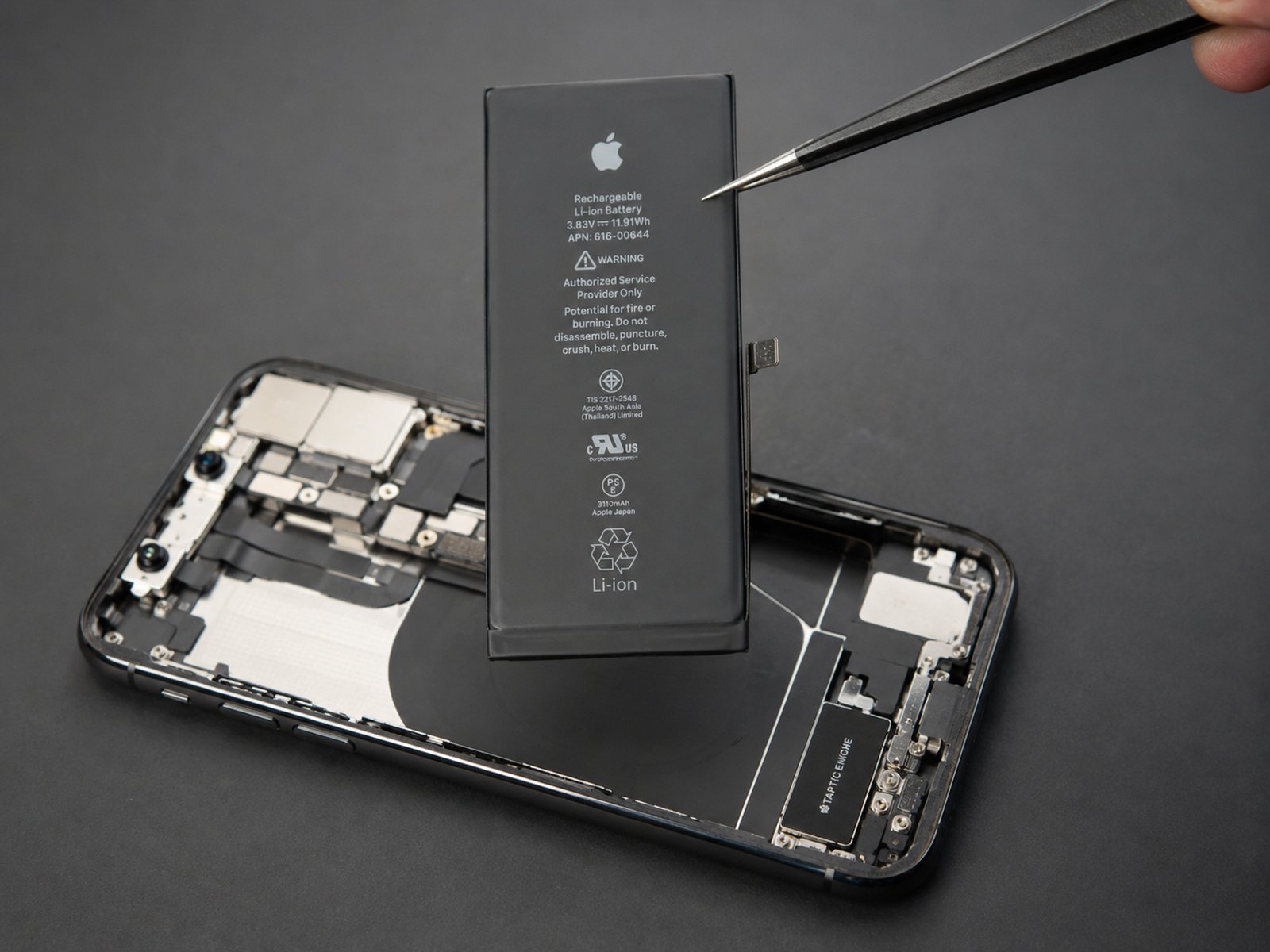 Réparation de batterie iPhone, ambiance sombre avec lumière rouge
